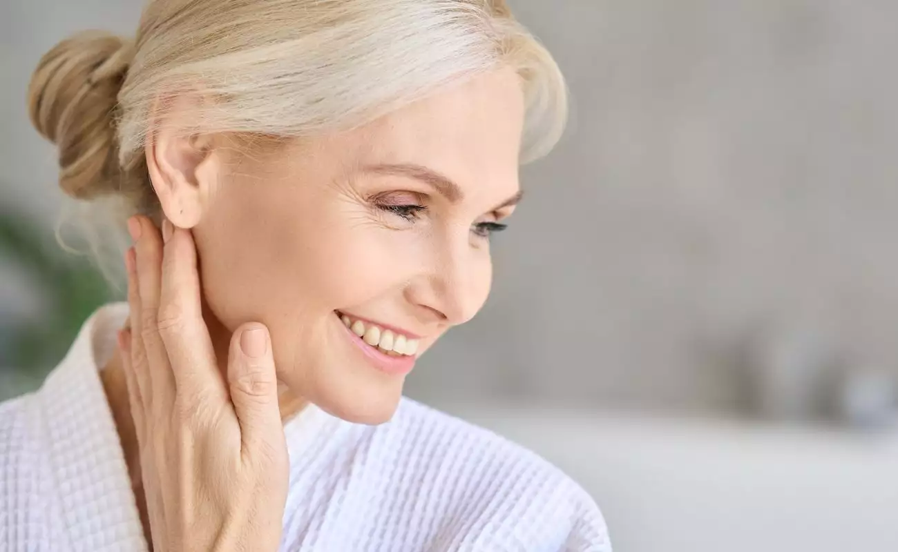 Photo of a smiling older woman with beautiful hair, skin and nails.