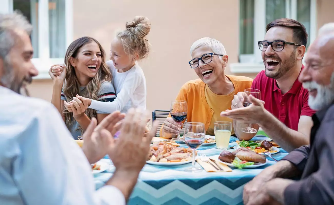 Photo of a multi-generational family on the patio enjoying dinner.